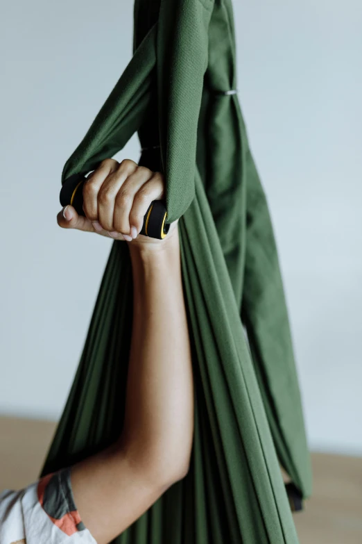 woman in green dress holding onto large fabric