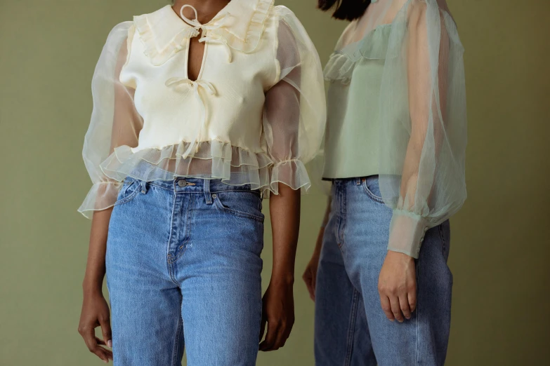 two models in jeans and white blouses stand together