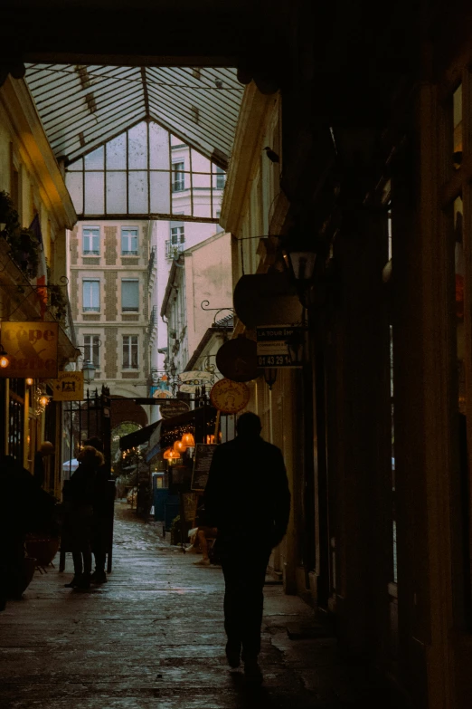 a dark alley with people walking along the sidewalk