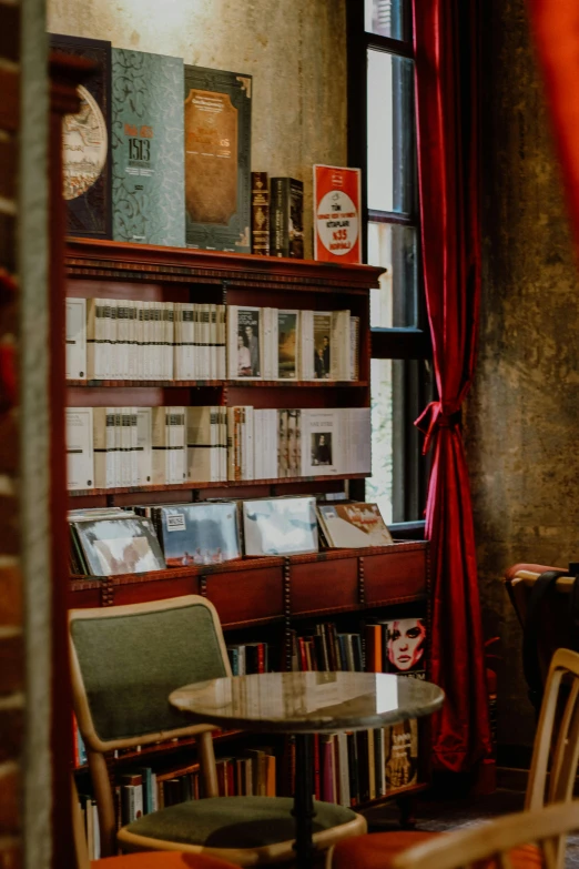 a liry with books, magazines and a chair