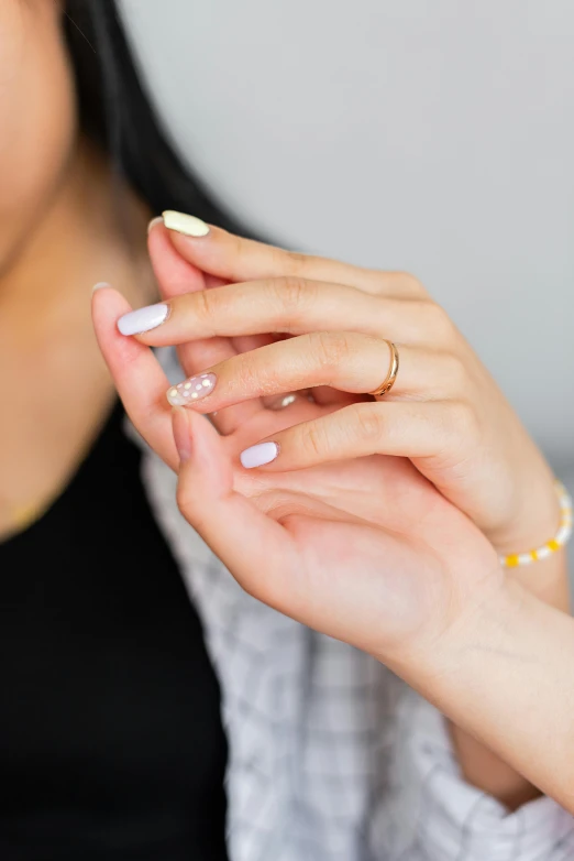 a woman in black shirt and yellow ring with a gold ring on her fingers