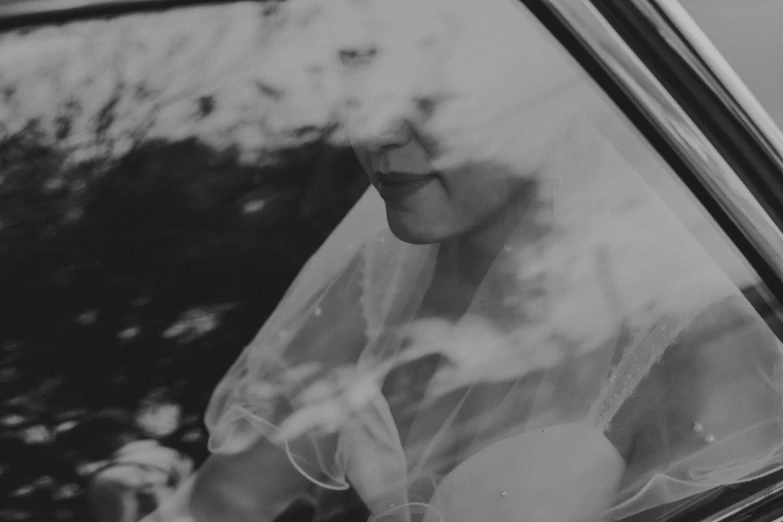 a woman is in her wedding dress on the back of a car