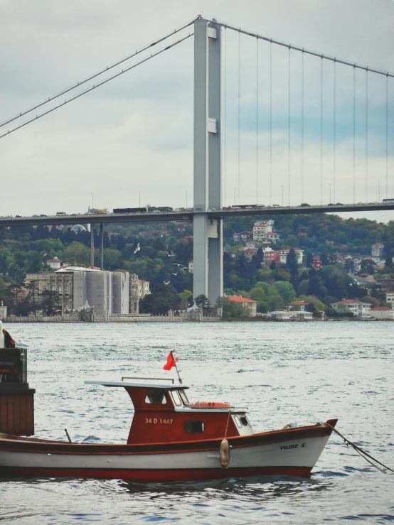 a boat in the water in front of a bridge