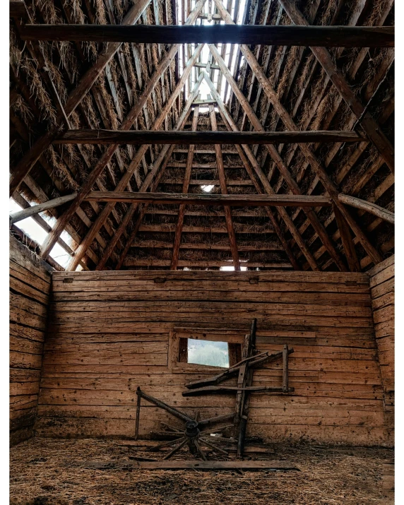 an old straw barn with windows and wood roofing