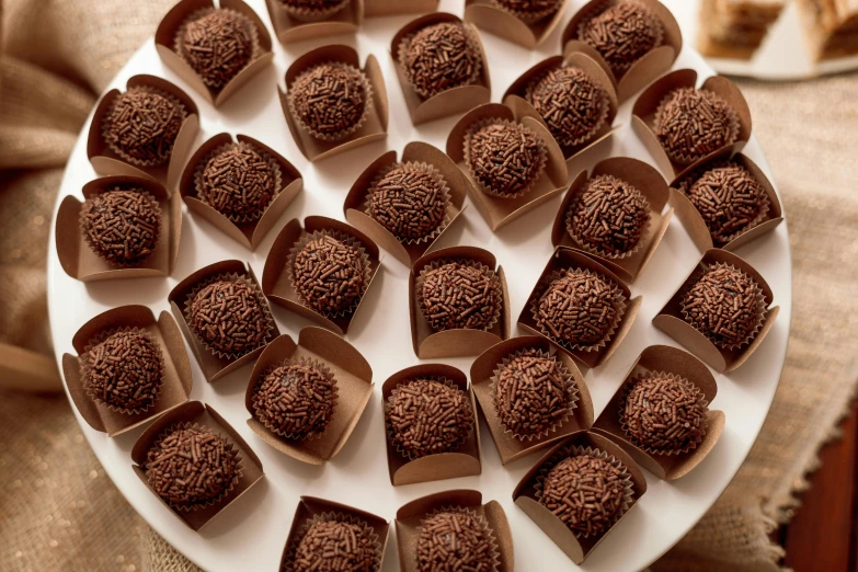 a plate of chocolate covered desserts sitting on a table