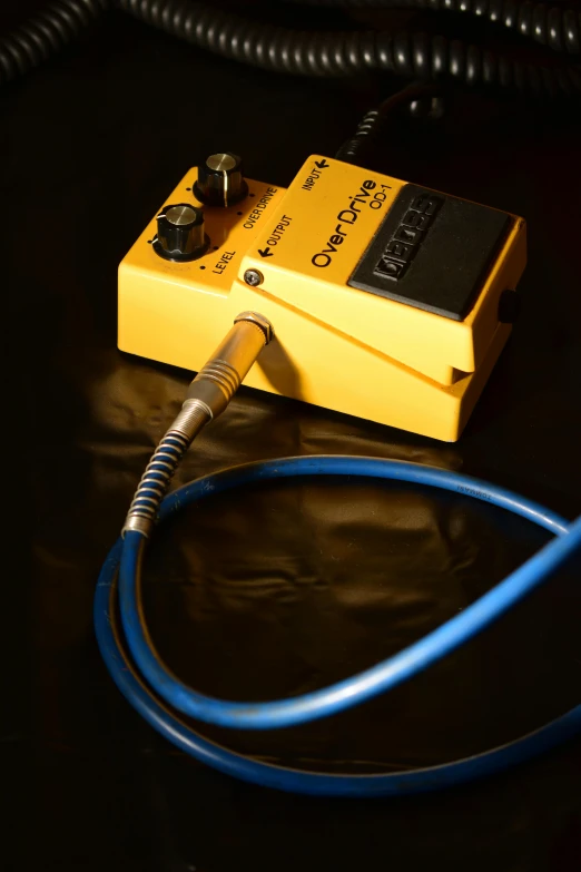 a blue coiled cable on top of a yellow box