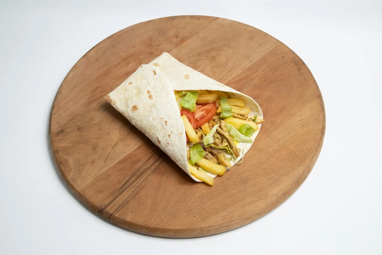 a tortilla sitting on top of a wooden platter