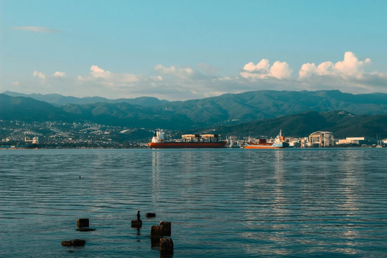 a big boat on the water with some mountains in the background