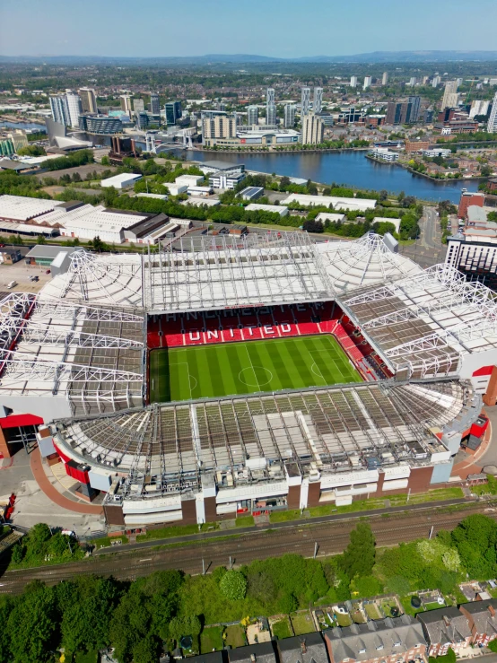 a large soccer field is located in front of the river and buildings