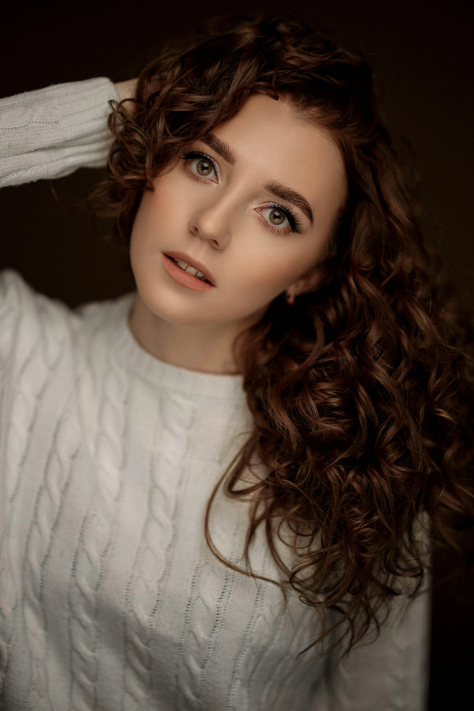 a girl with curly brown hair is looking to the side