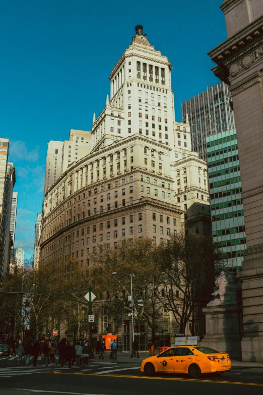 an old building with people standing around on the sidewalk