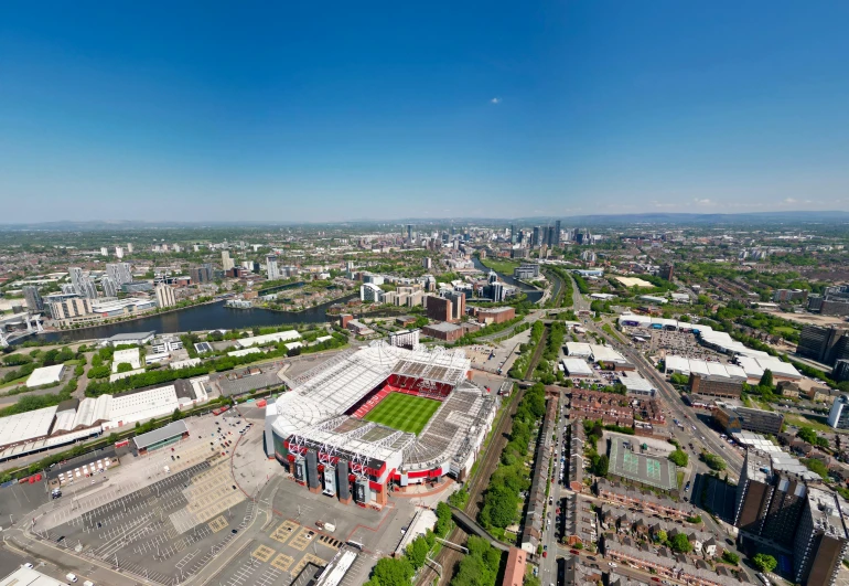 an aerial view of a large stadium soccer field with buildings and other streets surrounding it