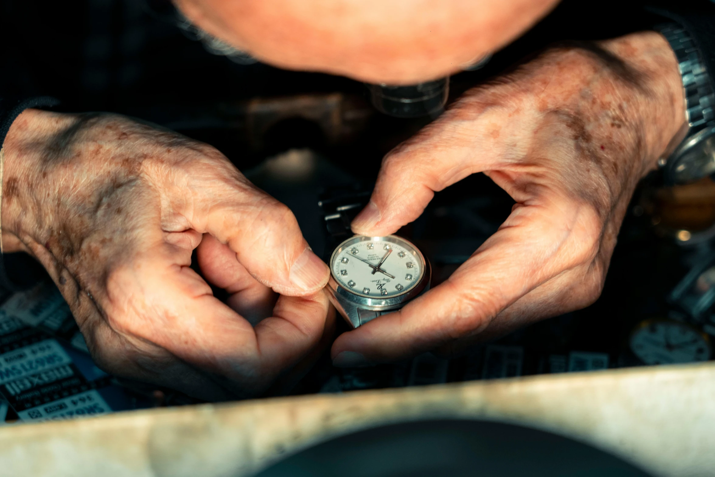 an old man holding a pocket watch in his hands