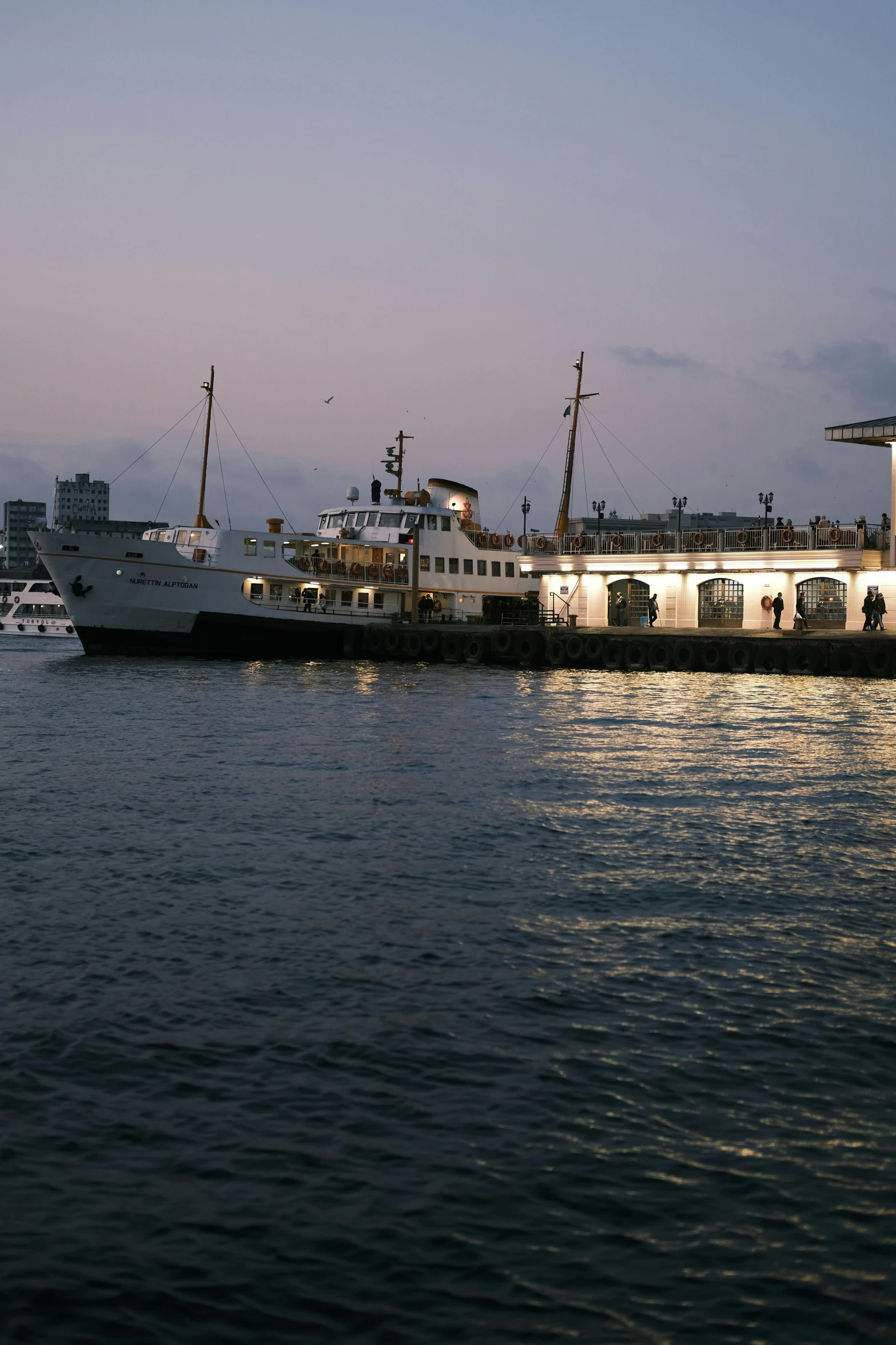 a large body of water with a boat and buildings in the distance