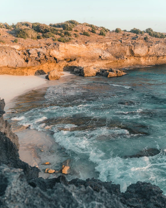 the ocean water is foamy by rocks