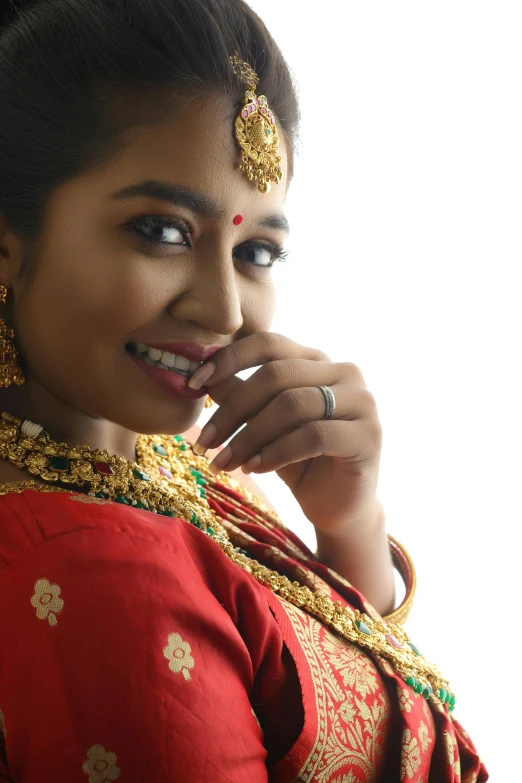 an indian woman wearing a red outfit with gold jewelry