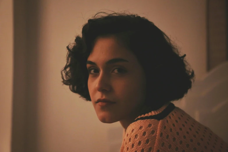 a woman with curly hair and a sweater