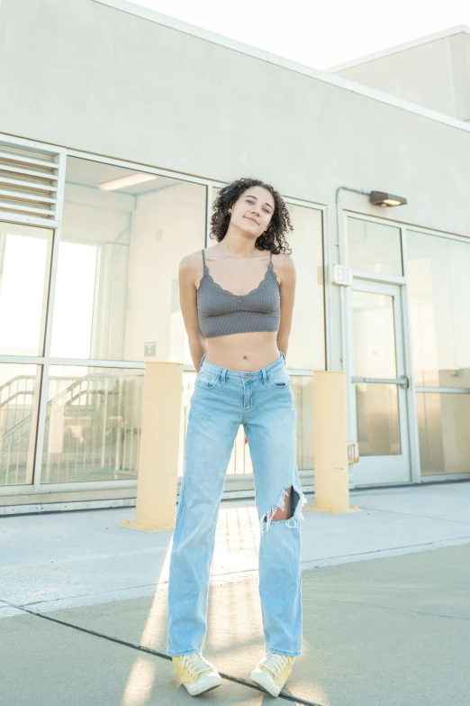 a young woman in high rise jeans posing for a po