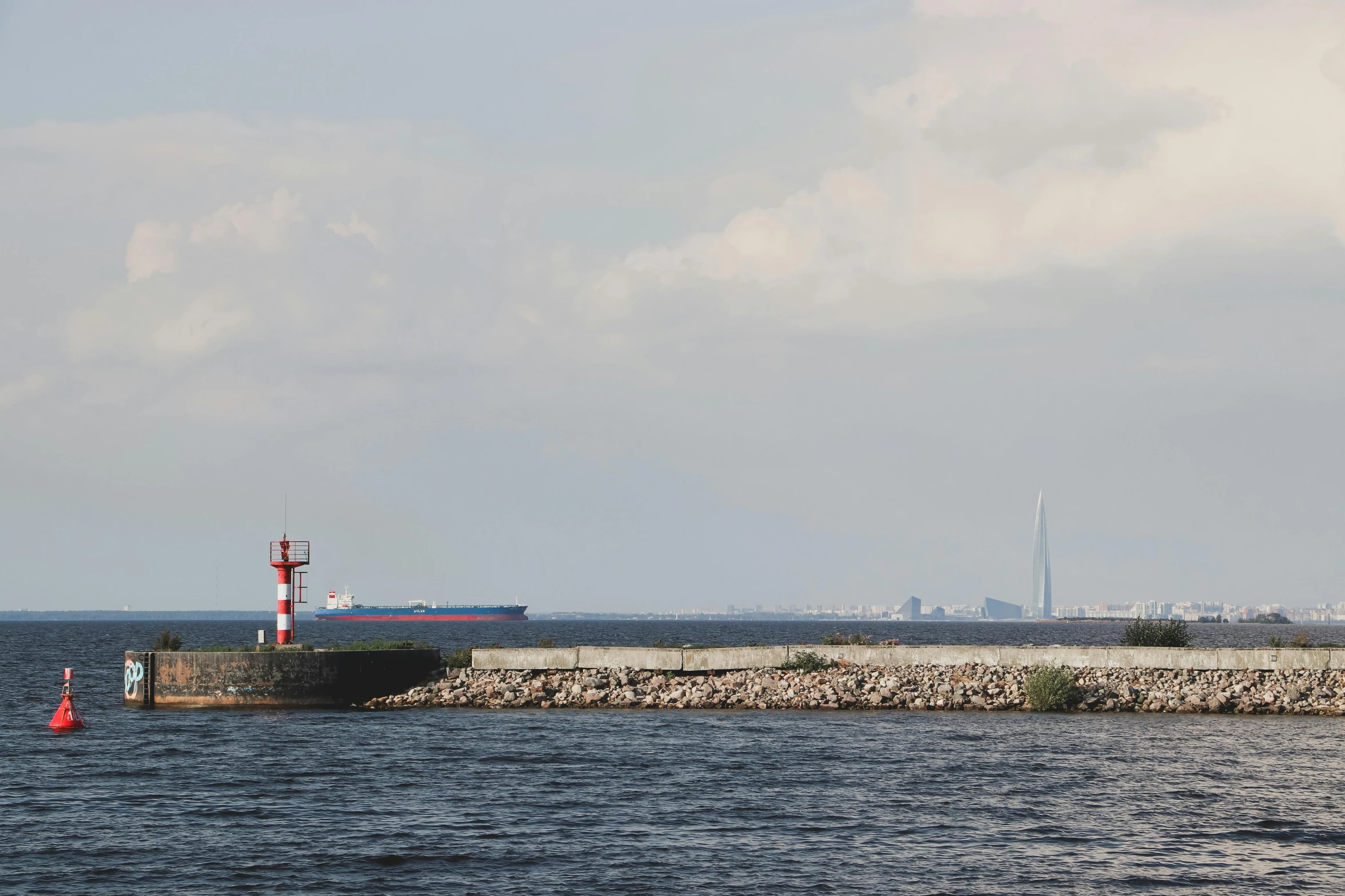 a barge out on the water in front of a lighthouse