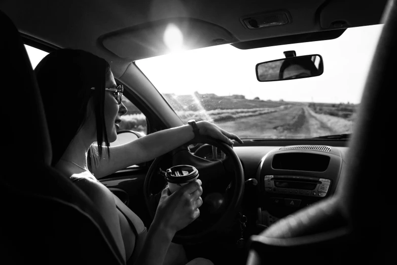 someone driving in the car and holding a beer in their hand