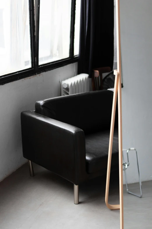 a black leather couch sits in a dimly lit room