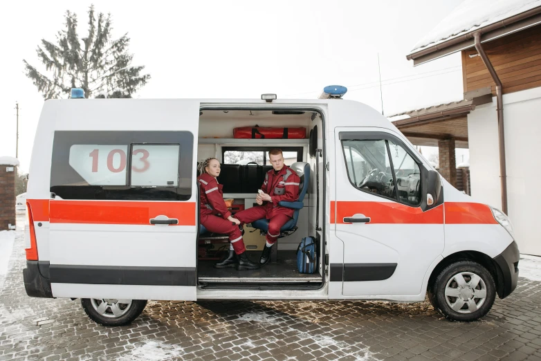 two men sitting in the driver's compartment of an emergency vehicle