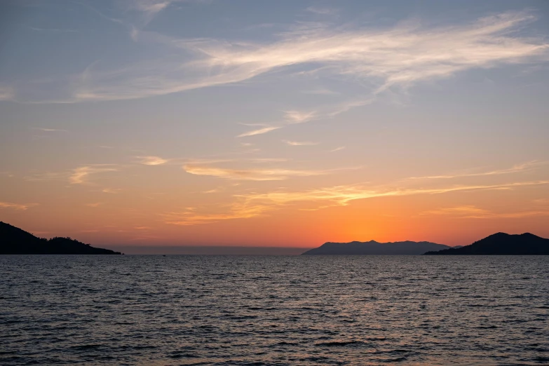 a beautiful sunset over the water and mountains