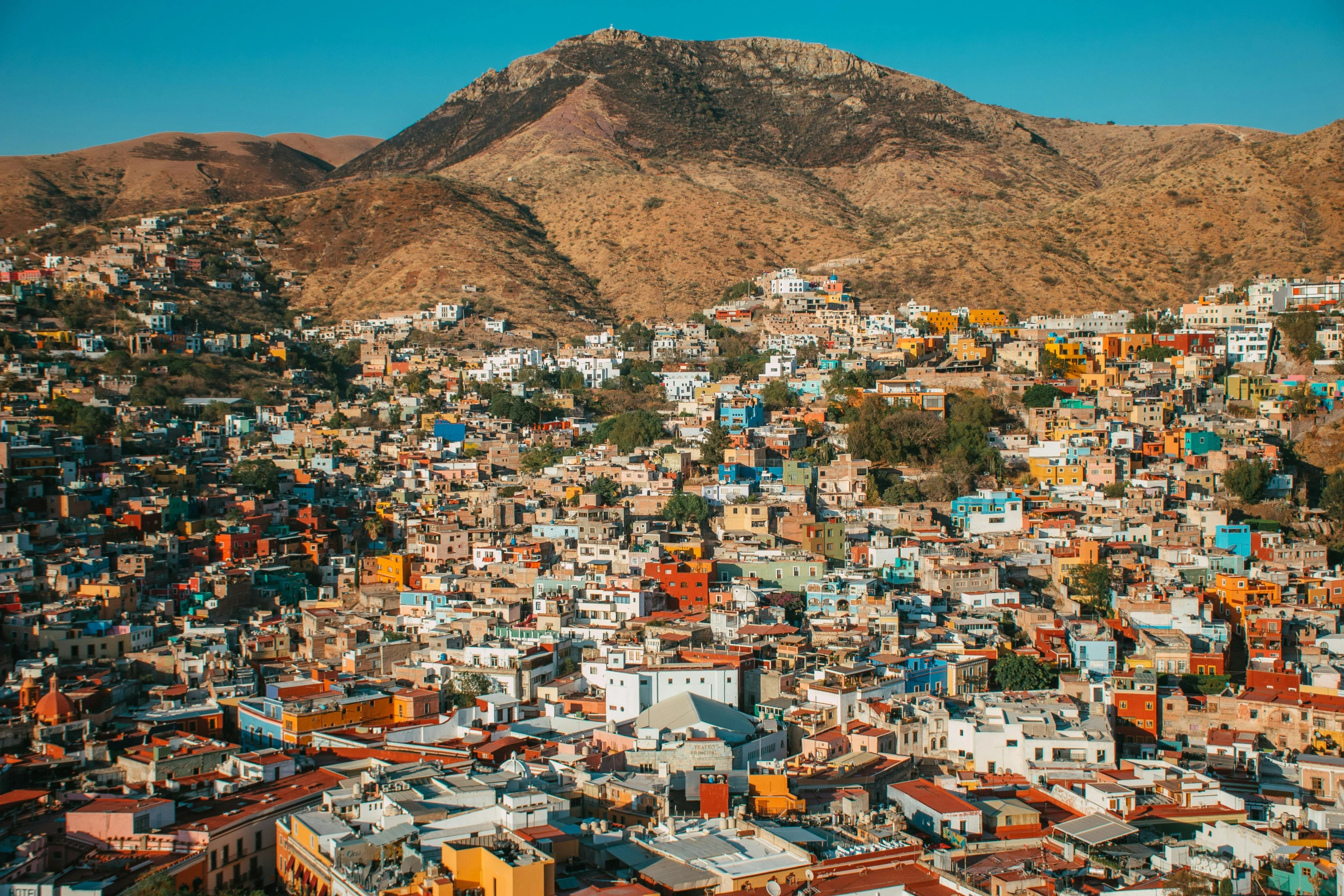 aerial view of colorfully painted houses, mountains and city