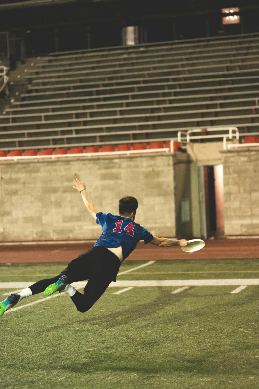 a man diving for a frisbee on a football field