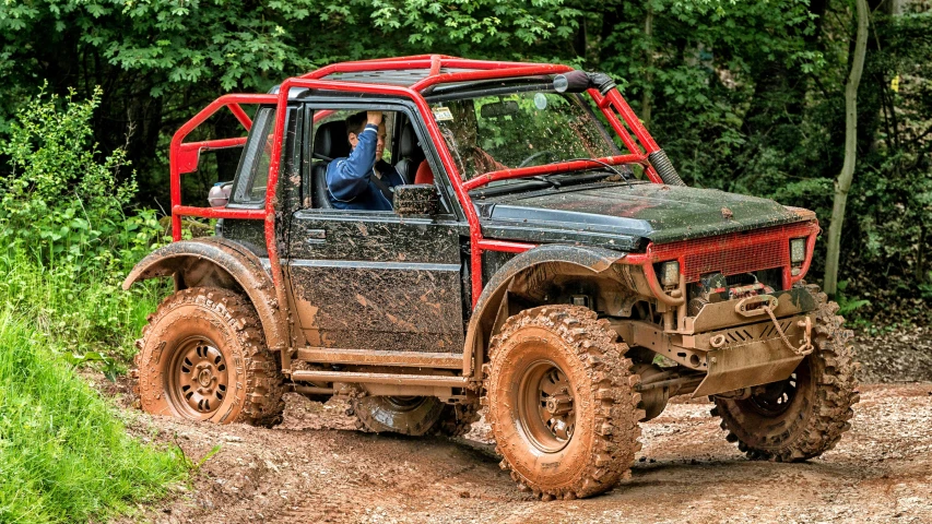 a small truck riding on top of a muddy road