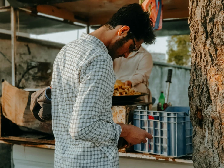 a man wearing glasses at an outdoor food stand