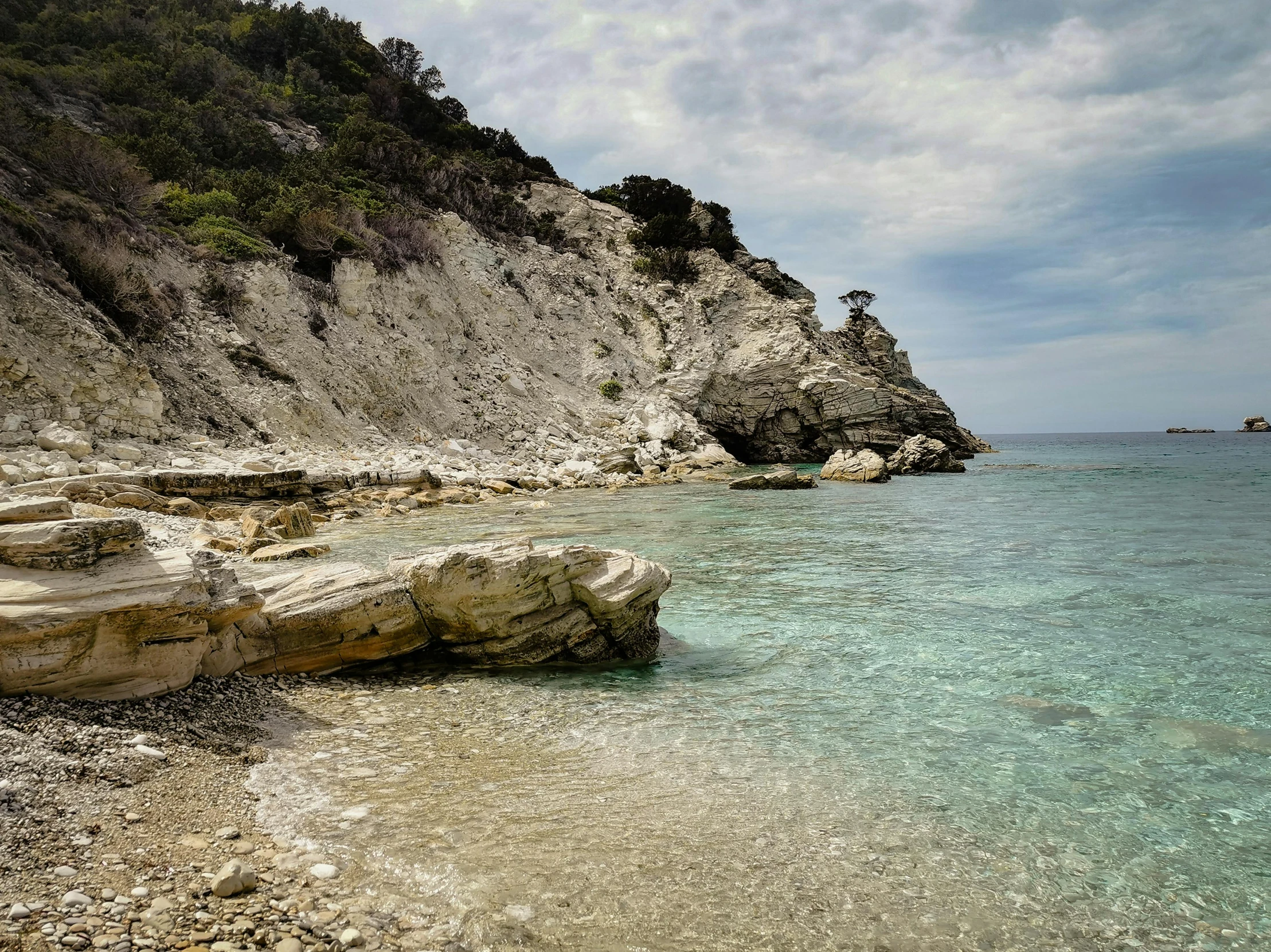 a lone boat is seen at an unspoible clear beach