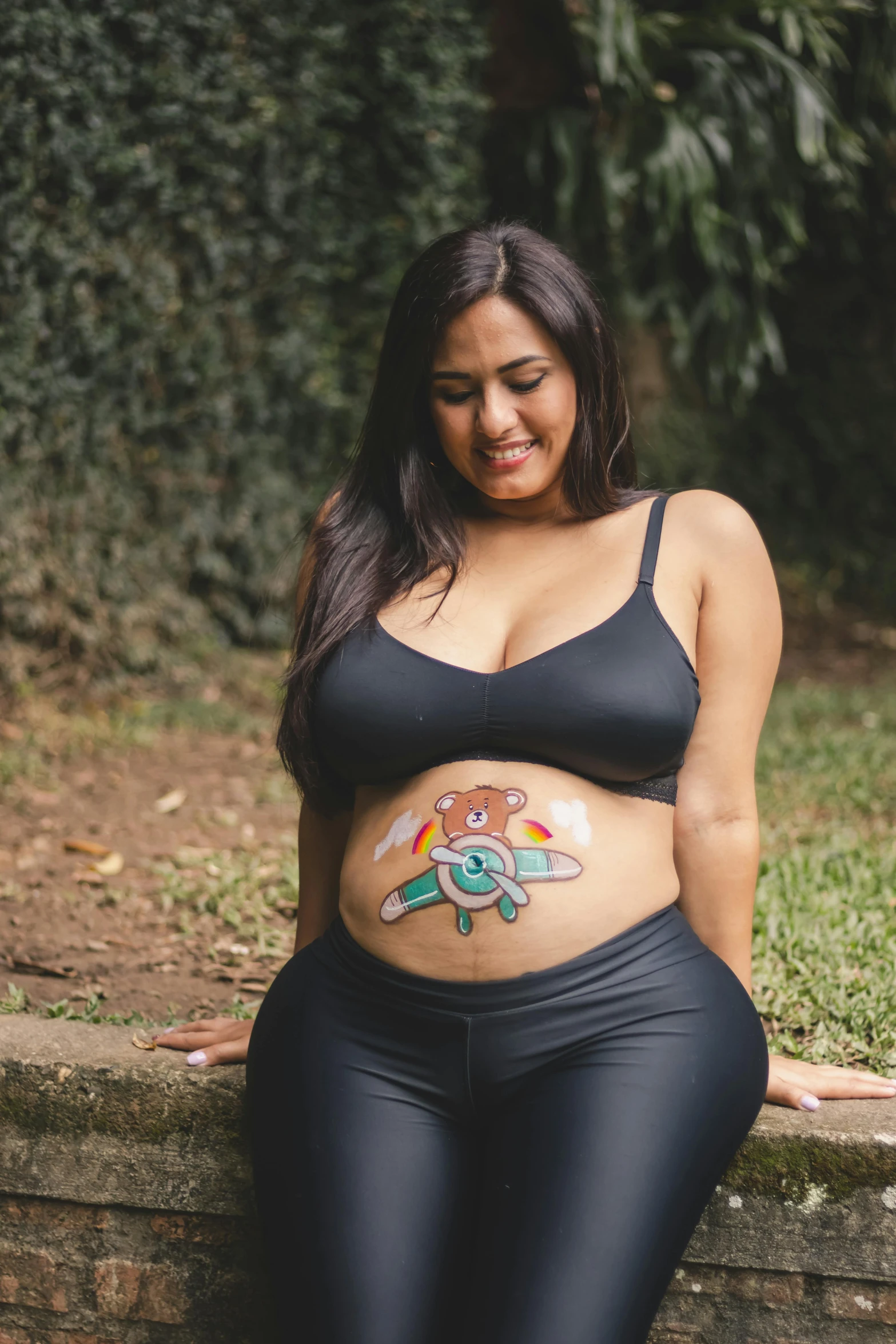 a very attractive woman wearing black wetsuit and panties with an emblem painted on her stomach