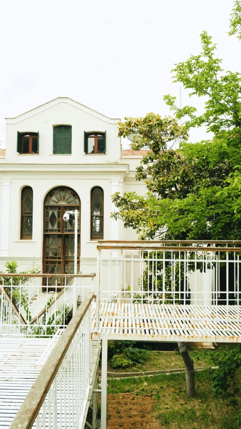 a white house sitting next to a lush green field