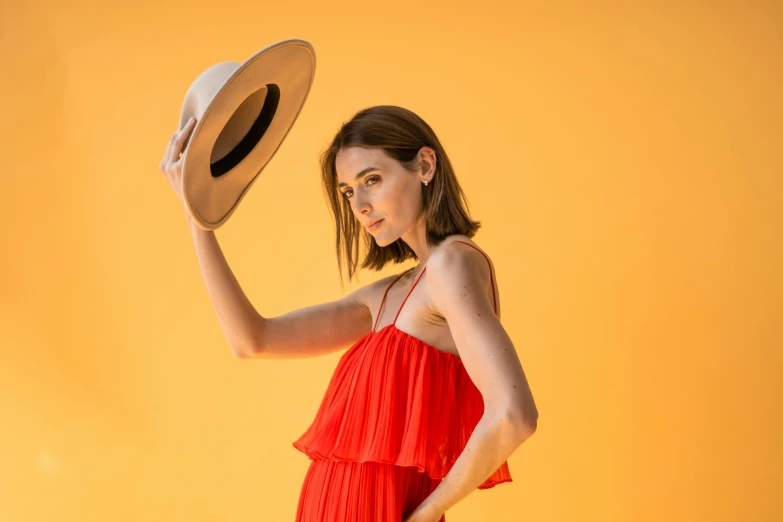 a woman wearing an orange dress and a hat