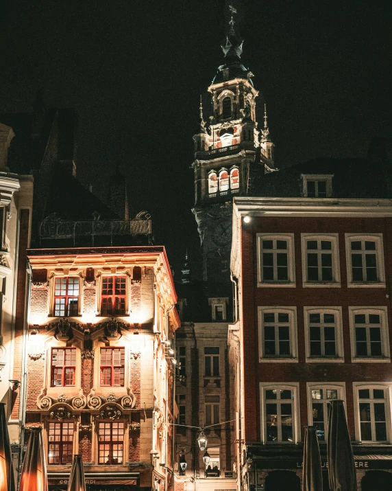 a clock tower standing over a row of parked cars