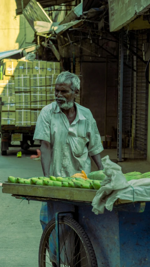 a man pulling a cart of food that is on the street