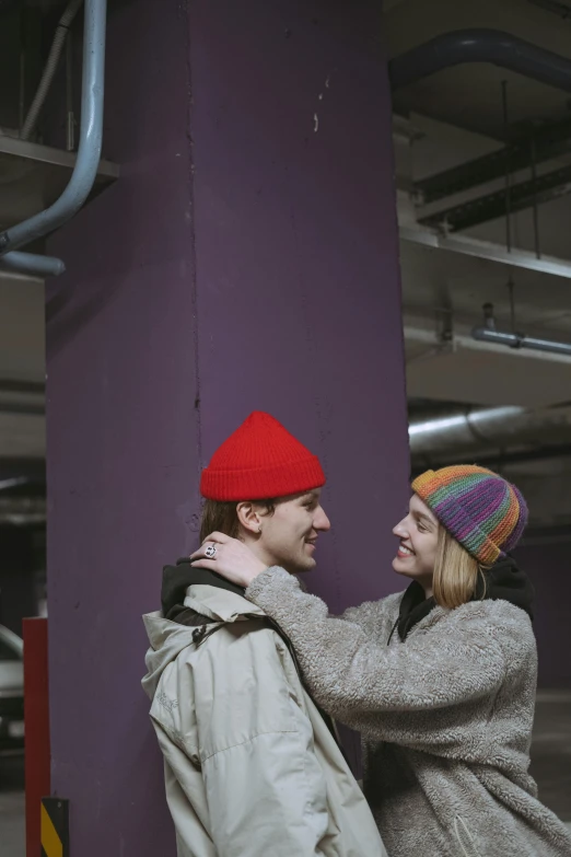 a couple of people standing next to a purple wall