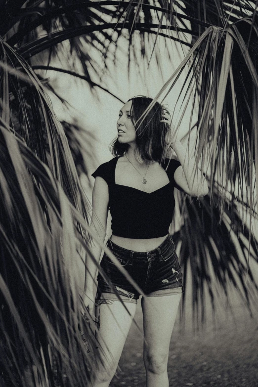 a woman standing by a tree looking away from the camera