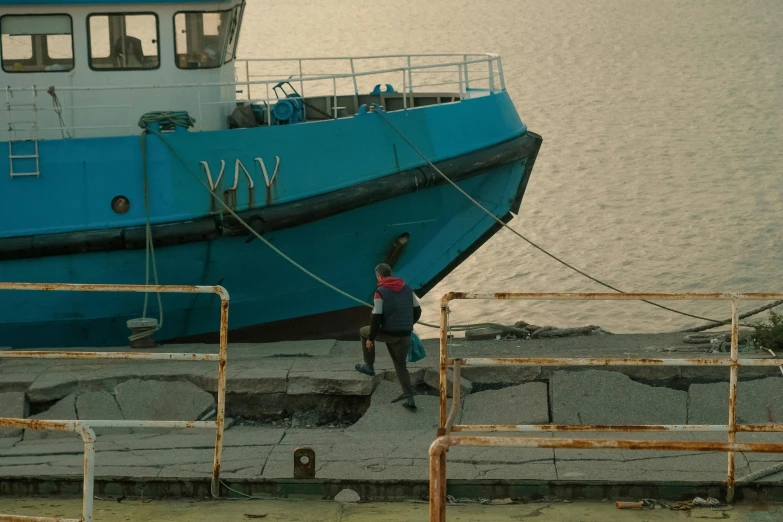 two people standing on a dock next to a boat