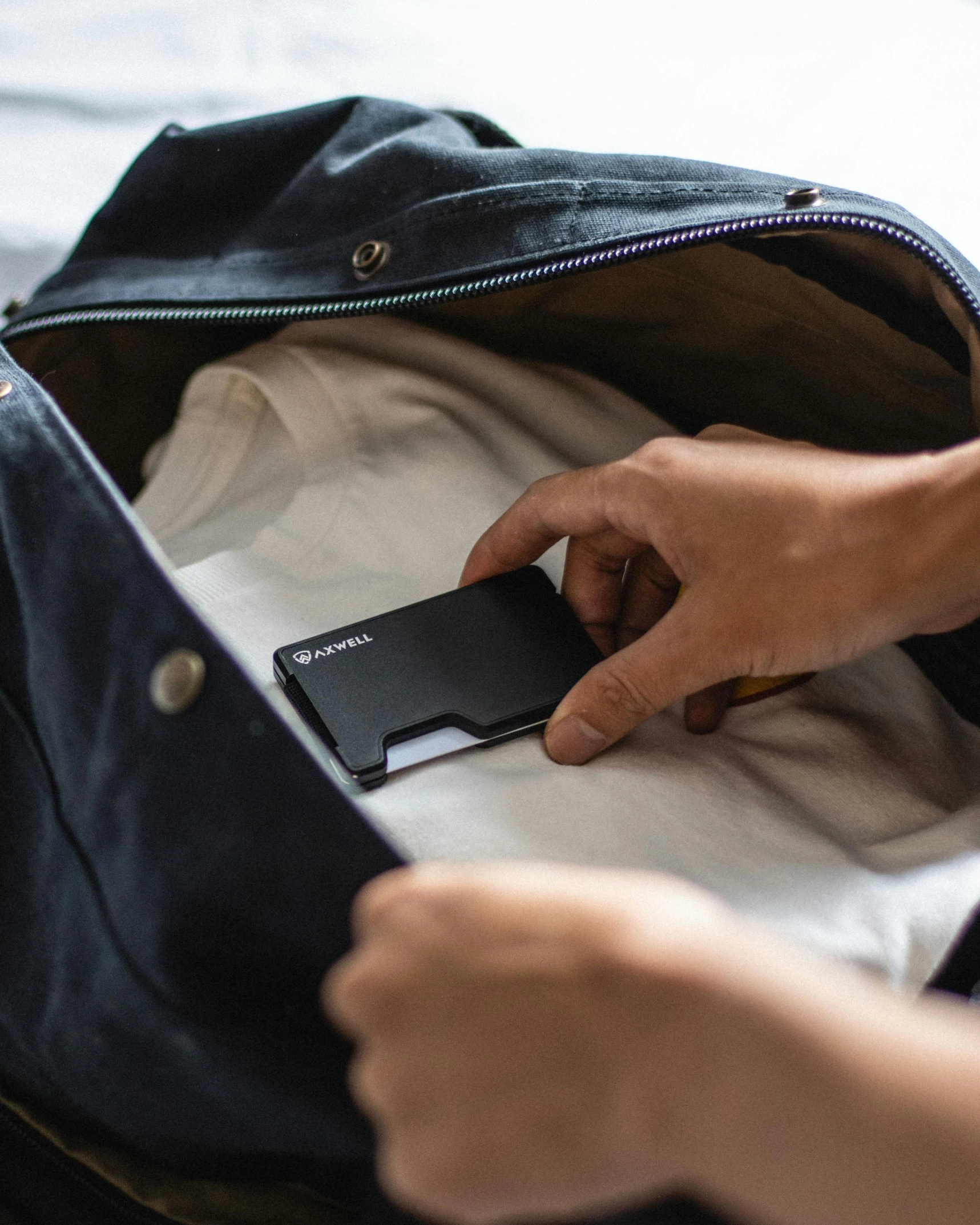 person pulling cover off purse for unpacking