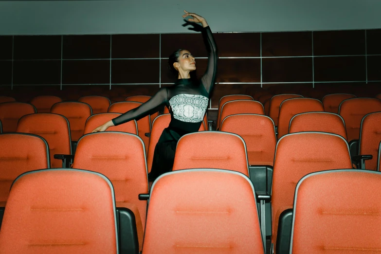 a woman is standing in the middle of a room with a lot of chairs