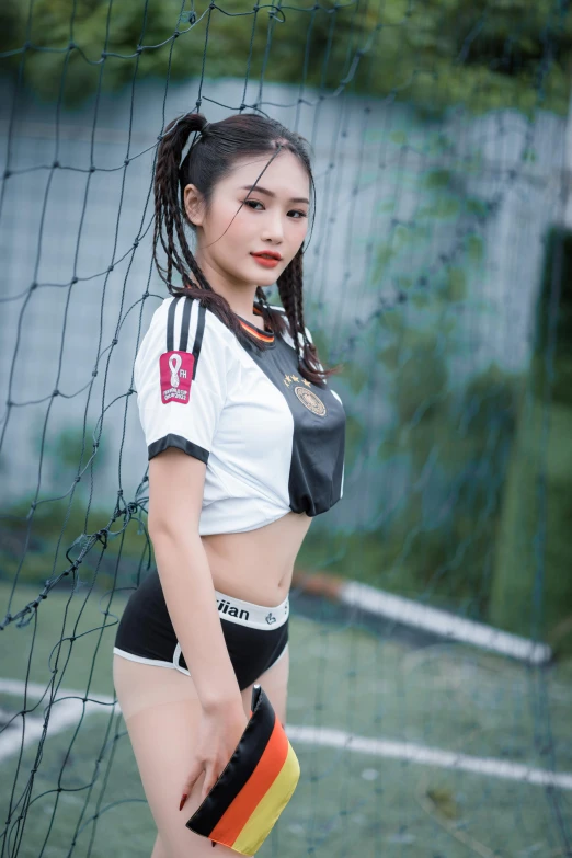 this asian girl poses for the camera with her soccer uniform