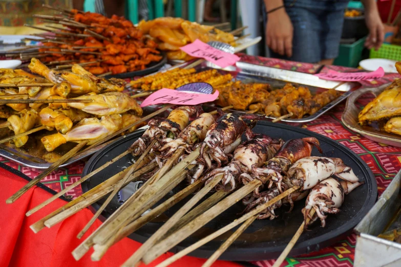 many skewers of food with chopsticks on them