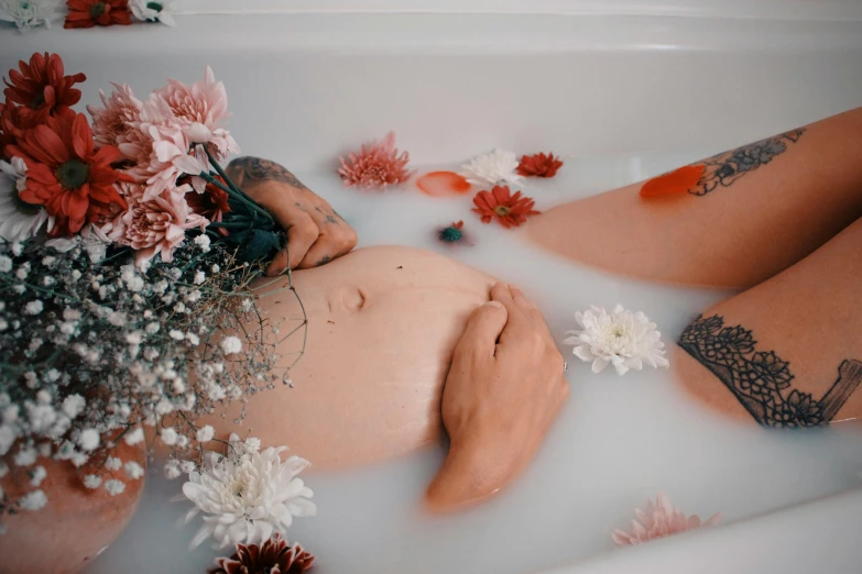 a  woman with tattoo lying in the bathtub