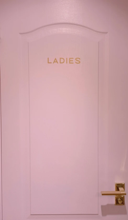 a pink door that says ladies in gold is shown