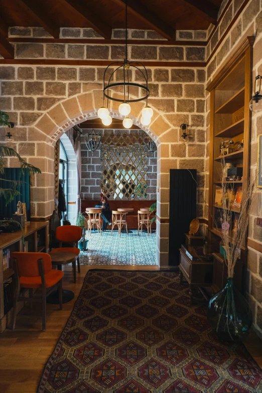 a living room with brick walls, a large rug and chairs