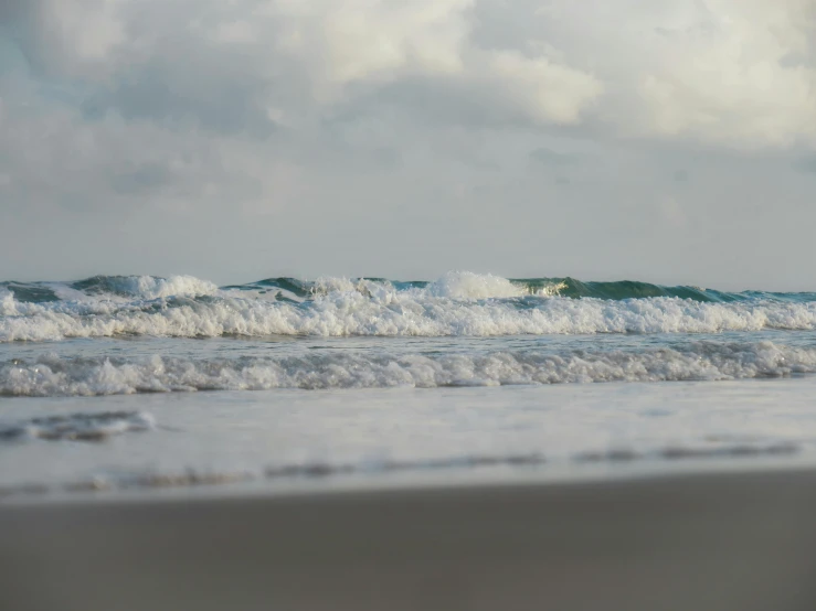 a small wave rolls over the top of a beach