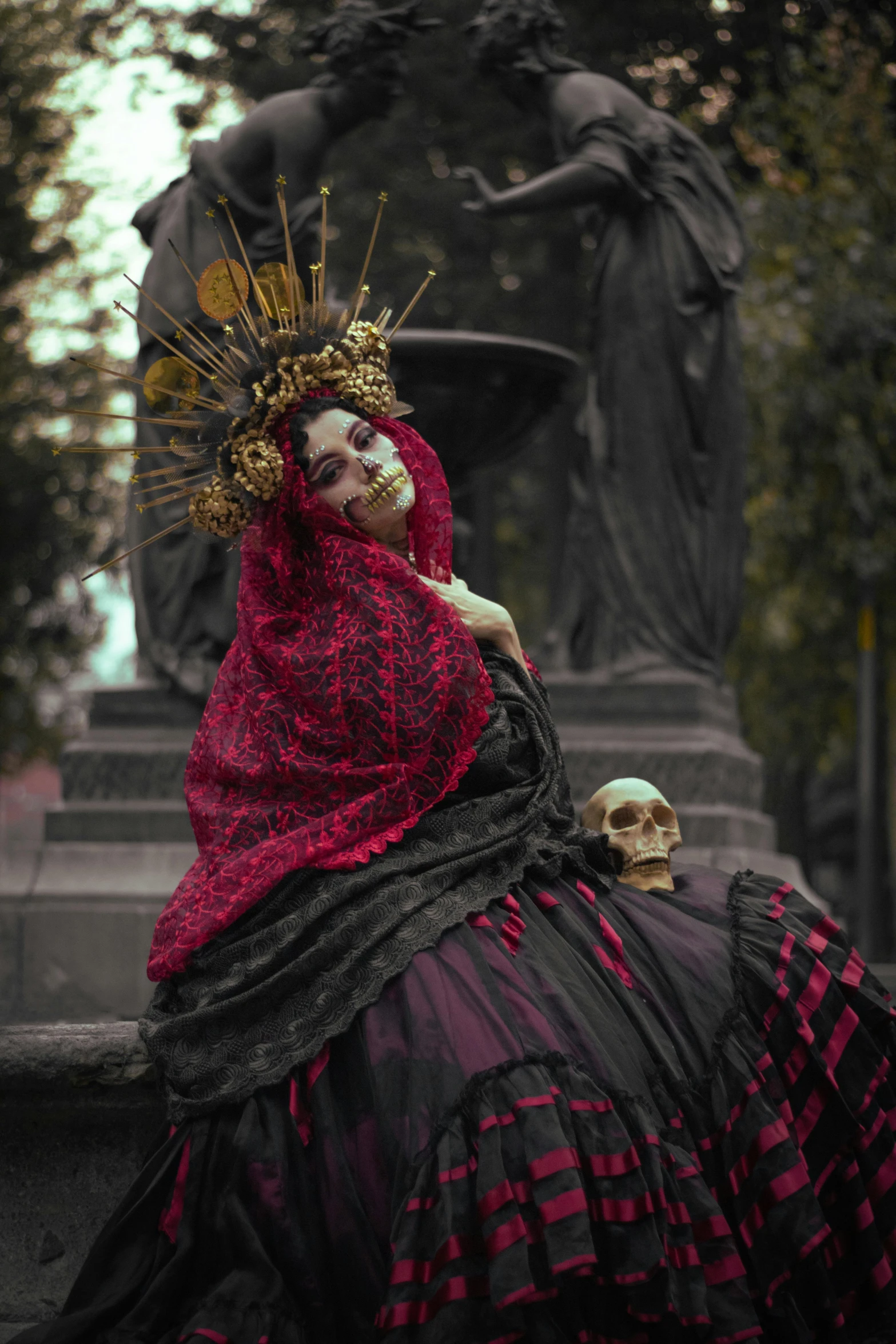 a woman in an elaborate dress and a skull on the ground