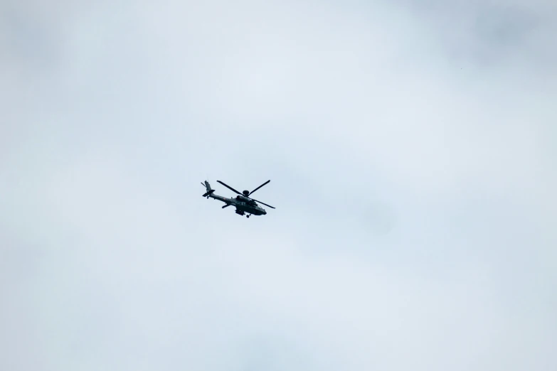 a plane is flying through the sky under a light blue cloud